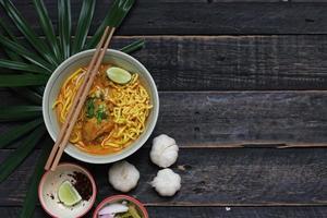 khao soi recept, khao soi, khao soi kai, thai nudlar khao soi, kycklingcurry med kryddor serveras på träbord foto
