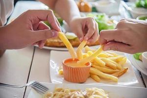 familjetid äta pommes frites tillsammans - familjeliv med matkoncept foto