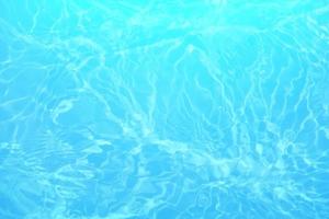 oskärpa suddigt blått vatten som lyser i havet. krusade vatten detalj bakgrund. vattenytan i havet, havsbakgrund. vatten våg under havet textur bakgrund. foto
