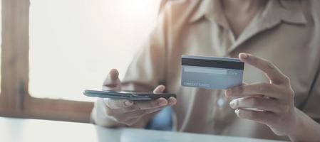 kvinna händer som håller smartphone shopping online med kreditkort. online betalning. online shopping koncept. foto