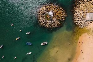 Uppifrån och ner flygbild av människor vid Praia Velha vilket betyder gammal strand vid Paco de Arcos-bukten i Oerias, Lissabon-regionen, Portugal foto