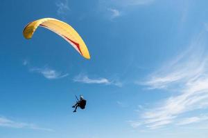 paraglider flyger i blå himmel. foto