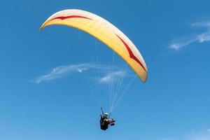 paraglider flyger i blå himmel. foto