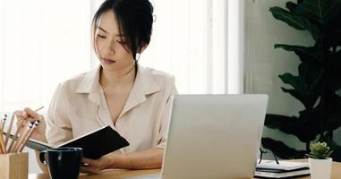 vacker ung asiatisk affärskvinna som arbetar tillsammans med digital surfplatta på kontoret. foto