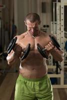 ung man tränar biceps hantel koncentration lockar