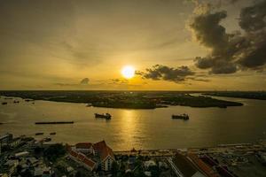 fågelperspektiv av samut prakan, thailand. solnedgång över floden chao phraya, orange himmel. foto