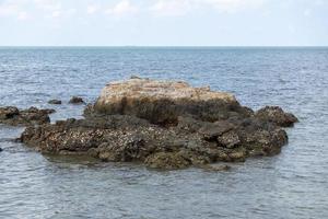 bruna stenar på det blå havet, havet vid middagstid foto