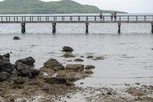 klippor i havet på baksidan, med utsikt över den ursprungliga bron, med utsikt över sattahip havet. foto