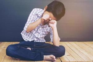 7 år gammal asiatisk pojke känner sig ledsen foto