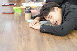 affärsman slå ner på skrivbordet. överbelastning arbetar eller försämrad hälsa eller misslyckande verksamhet nedåtgående trend. sover på skrivbordet på jobbet. foto