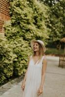 ung kvinna med hatt promenader i resort trädgård foto