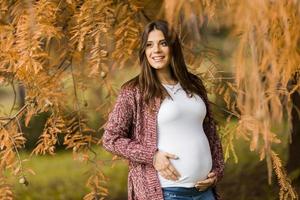 ung gravid kvinna i höstparken foto