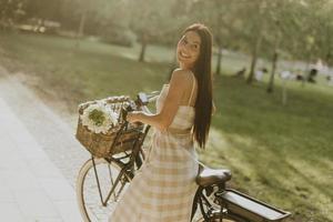 ung kvinna med blommor i korgen med elcykel foto