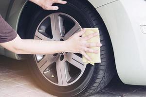 man rengör och vaxar bilen - utomhuskoncept för bilunderhållsservice foto