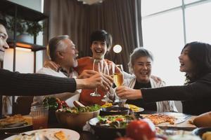 asiatisk familj äter middag vid matbordet hemma foto