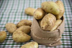 färsk potatis i köket redo att tillagas - färska grönsaker som förbereder sig för att göra matkoncept foto
