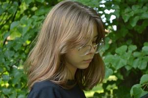 porträtt av en flicka nära grönskan, närbild foto