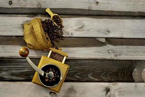 vintage kaffekvarn. gammal retro handdriven kaffekvarn av trä och metall. manuell kaffekvarn för malning av kaffebönor. på den gamla träbakgrunden. foto