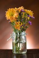 vacker blomma i vas på bordet foto