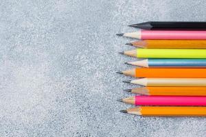 ljusa färgade pennor på det grå bordet. konceptskola. kopieringsutrymme foto