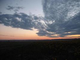 morgongryning på himlen och ett fält i byn foto