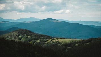 gröna berg av Karpaterna mitt i skogen mot bakgrund av en dramatisk himmel foto