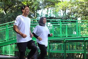 muslimska par joggar och springer utomhus i naturen. hälsosam familj livsstil koncept. foto