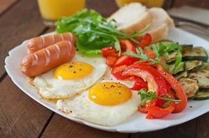 engelsk frukost - stekt ägg, korv, zucchini och paprika foto