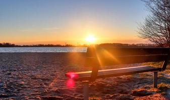 vacker och romantisk solnedgång vid en sjö i gula och orangea färger foto