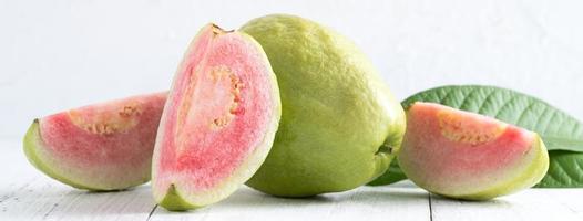 närbild av vacker röd guava med färska gröna blad. foto