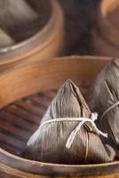 ris dumpling, zongzi - kinesisk ris dumpling zongzi på svart tegel bakgrund skiffer bord, begreppet drakbåt festival traditionell mat, närbild. foto