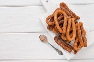 hemlagad churros på en vit trä bakgrund. foto