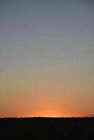 en klar kvällssolnedgång med blå och gula reflektioner. vacker klar solnedgång. foto