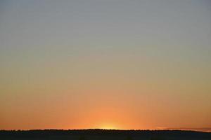 en klar kvällssolnedgång med blå och gula reflektioner. vacker klar solnedgång. foto