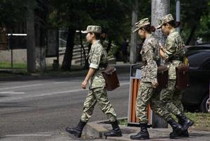 almaty, kazakstan - 24 augusti 2019 - tre kvinnor i uniform korsar en gata i almaty. foto