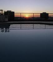 solnedgång i Lissabon, Portugal, sett från ett tak med pool foto