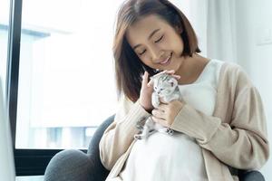 porträtt av unga asiatiska gravid med kattunge foto
