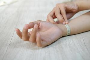 kvinnlig hand som mäter handleden med ett måttband foto
