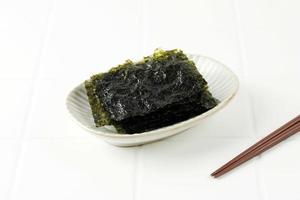 saltat nori laver ark på vit platta, populärt i Japan och Korea för sushi och kimbap foto