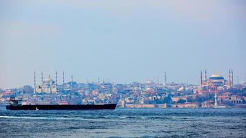 oljetanker i Bosporen med gamla staden i bakgrunden hagia sophia foto