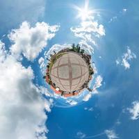 liten planetomvandling av sfäriskt panorama 360 grader. sfärisk abstrakt flygfoto i liten stad med fantastiska vackra moln. utrymmets krökning. foto