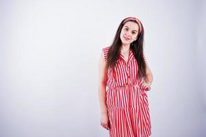 porträtt av en vacker ung flicka i rödrandig klänning i studion. foto