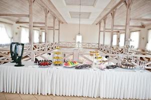 vacker bröllopsgodisbar med godis, frukt och mat. bröllopsbankettbord foto