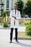 snygg afrikansk amerikansk läkare med stetoskop och labbrock poserade på bakgården till sjukhuset. foto