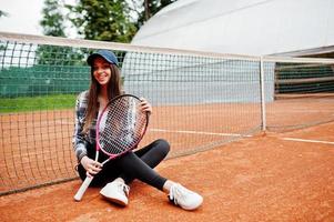 ung sportig tjejspelare med tennisracket på tennisbanan. foto