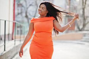 afrikansk amerikansk kvinna modell xxl i orange klänning. foto