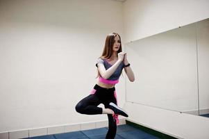 ung brunett sexig smal tjej gör träning på gym. foto
