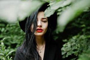 närbild porträtt av sensuell tjej i svarta, röda läppar och hatt. goth dramatisk kvinna. foto