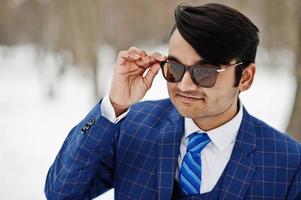 närbild porträtt av elegant indisk affärsman i kostym och solglasögon poserade på vinterdag utomhus. foto