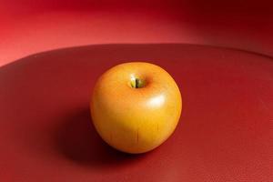 äpple på röd bakgrund svagt ljus för matinnehåll. foto